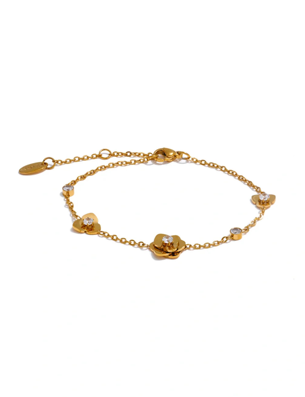 The Petal Gold Flower Charm Bracelet features delicate flower-shaped charms, sparkling cubic zirconia stones, an adjustable clasp, and a small branded tag at the end.