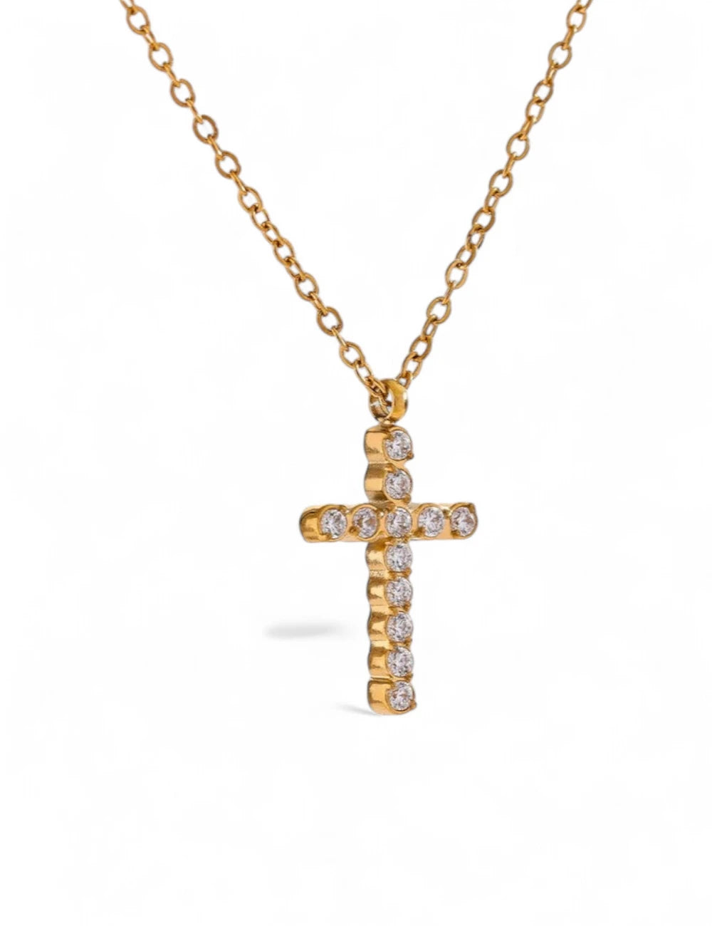 The Grace Cross Pendant Necklace features a gold plated cross adorned with sparkling cubic zirconia stones, showcased on a simple white background.